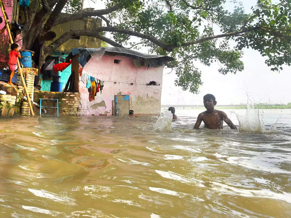 Two men, in flood-ravaged Lakhimpur Kheri, walk home with their sister's body 