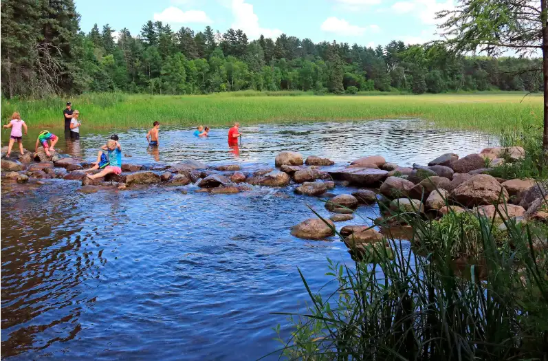 general ​Children play in the outlet of Lake Itasca in Minnesota, the source of the Mississippi River.