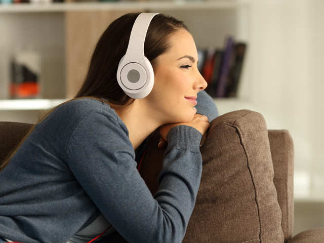 Singing reading. Listening to Music at Home with Bluetooth Headset. Modern Music and after.