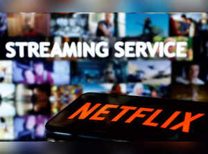 FILE PHOTO_ A smartphone with the Netflix logo lies in front of displayed _Streaming service_ words in this illustration.