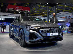 A salesman stands next to the new electric Audi Q8 e-tron car which display at t...