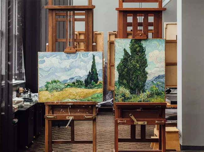 Vincent van Gogh’s “Wheat Field With Cypresses,” left, and “Cypresses,” seen in the conservation center at the Metropolitan Museum of Art in New York on April 27, 2023. A revelatory show at the Metropolitan Museum of Art reunites 24 paintings of cypresses and unchains them from their somber associations. (George Etheredge/The New York Times)