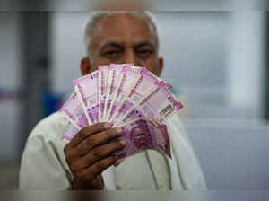 New Delhi: A man holds Rs 2000 currency notes at a bank in New Delhi. The Reserv...