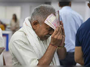 New Delhi: A man holds Rs 2000 currency notes at a bank in New Delhi. The Reserv...