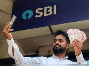 Dhanbad: A man takes a selfie before deposit currency of Rs. 2000 at SBI, in Dha...