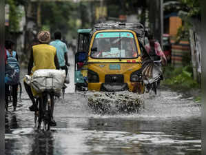Balurghat: Vehicles ply on a road following a heavy rainfall, at Balurghat in So...