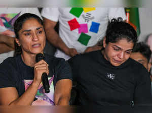 New Delhi: Protesting wrestlers Vinesh Phogat (L) and Sakshi Malik react during ...