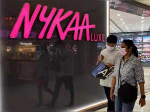 FILE PHOTO_ People walk past a store of Nykaa, an Indian beauty products retailer, at a mall in New Delhi.