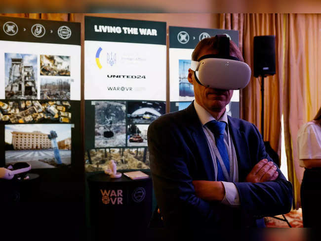 A person wears a virtual reality (VR) headset with images about the war in Ukraine during the Globsec's regional security forum in Bratislava, Slovakia, on May 31, 2023.   (Photo by Ludovic MARIN / AFP)