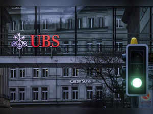 A traffic light signals green in front of the logos of the Swiss banks Credit Su...