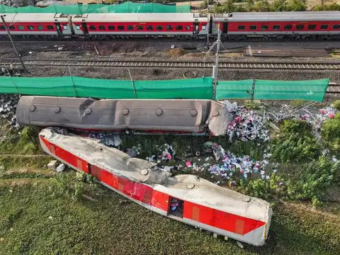 Train running past derailed coaches ​