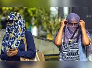 New Delhi: Commuters cover their face with scarf to protect themselves from the heat, amid scorching hot weather, in New Delhi, on Monday, April 17, 2023 (Photo: Wasim Sarvar/IANS)