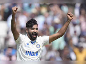 India's Mohammed Siraj celebrates after his teammate India's Axar Patel, who is ...