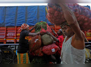 Labourers load vegetables on a bicycle at a fruit and vegetable wholesale market in Mumbai