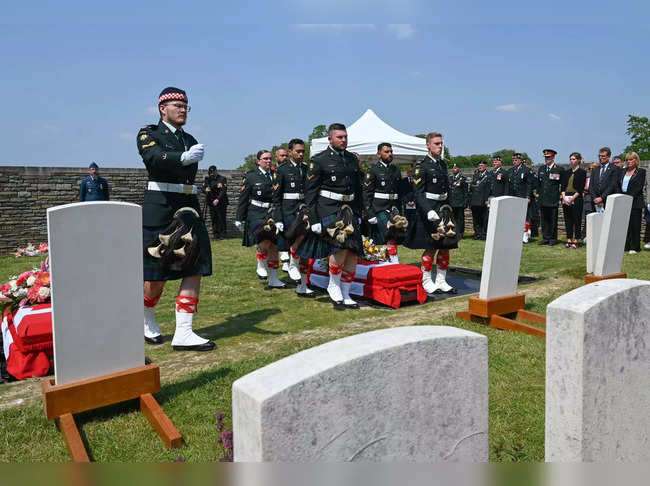 Soldiers from the Canadian Army's Calgary Highlanders stand in front of the coffin of one of the three Canadian soldiers who died during the First World War as they are buried during a funeral service at the English military cemetery of the Commonwealth War Graves Commission (CWGC) in Loos-en-Gohelle, near Lens, northern France, on June 8, 2023.  Three soldiers identified and being buried after more than a century are; Corporal Percy Howarth, born in Darwen, England in 1894; Harry Atherton, born in Leigh, England in 1893, and Sergeant Richard Musgrave, born in Blackrigg, Scotland in 1884.  (Photo by