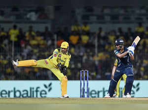 Gujarat Titans' Shubman Gill (R) plays a shot as Chennai Super Kings' Mahendra Singh Dhoni gestures during the Indian Premier League (IPL) Twenty20 first qualifier cricket match between Chennai Super Kings and Gujarat Titans at the MA Chidambaram Stadium in Chennai on May 23, 2023. (Photo by R.Satish BABU / AFP)