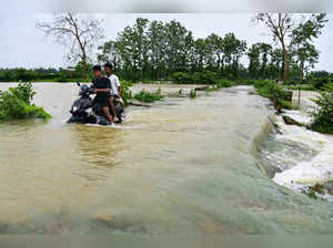 Nagaon : A man rides his two-wheeler as he wades through a flooded road following a heavy rain in Kampur, Nagaon District of Assam on Saturday, June 17, 2023.  (Photo:IANS/Anuwar Hazarika)
