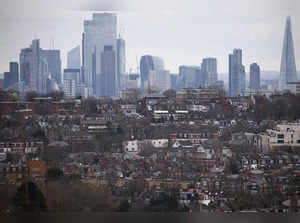 FILE PHOTO: Rows of houses lie in front of the City of London skyline in London