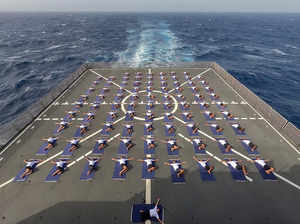 Navy personnel perform yoga on-board INS ...