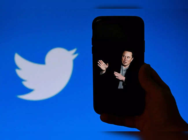 (FILES) In this photo illustration, a phone screen displays a photo of Elon Musk with the Twitter logo shown in the background, on October 4, 2022, in Washington, DC. Australia's internet safety watchdog on June 22, 2023 threatened to fine Twitter for failing to tackle online abuse, saying Elon Musk's takeover had coincided with a spike in "toxicity and hate".  -  (Photo by OLIVIER DOULIERY / AFP)