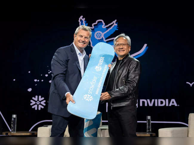 Snowflake Chairman and CEO Frank Slootman presents a snowboard as a gift to NVIDIA CEO Jensen Huang at Snowflake Summit 2023