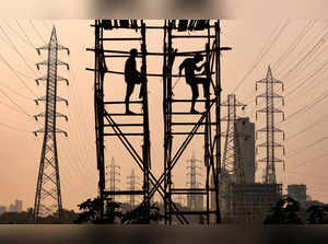 FILE PHOTO: Labourers work next to electricity pylons in Mumbai