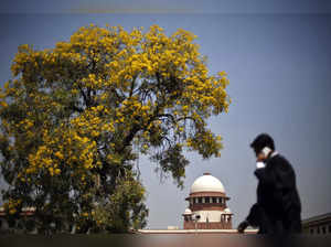 Lawyer speaks on his mobile phone as he walks past India's Supreme Court in New Delhi
