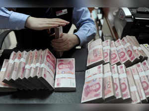 FILE PHOTO: FILE PHOTO: An employee counts 100 Chinese yuan banknotes at a bank in Hefei