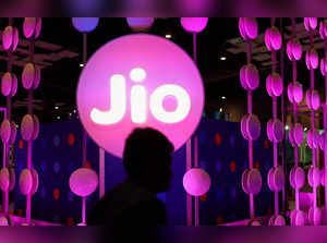 A man walks across the LED board showing the logo of Jio at the ongoing India Mobile Congress 2022, at Pragati Maidan, in New Delhi