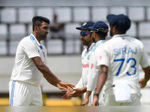 Ravichandran Ashwin (L) and Rohit Sharma (R), of India, celebrate the dismissal of Tagenarine Chanderpaul, of West Indies, during day one of the First Test between West Indies and India at Windsor Park in Roseau, Dominica, on July 12, 2023. (Photo by Randy Brooks / AFP)