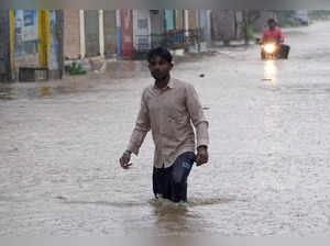Mandvi : A man walks through a waterlogged road amid heavy rain following the landfall of Cyclone Biparjoy in  Mandvi, Kutch, on Friday, June 16, 2023. (Photo: IANS/Siddharaj Solanki)