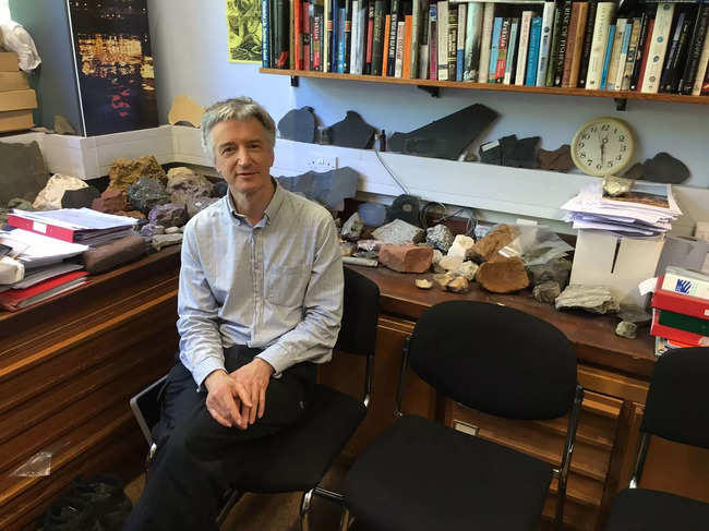 This handout photograph taken on May 26, 2017 and released by Jan Zalasiewicz on July 7, 2023, shows Jan Zalasiewicz, Emeritus Professor of Palaeobiology and the long-time chair of the Anthropocene Working Group, as he poses in his office at the University of Leicester in Leicester, central England. In 1981, newly minted palaeobiologist Jan Zalasiewicz assumed he was headed for a discreet career retrieving and deciphering fossils from Earth's deep past. For three decades the British scientist was, in his words, an itinerant geologist but then, curiosity and happenstance thrust him into the middle of a raging debate within science