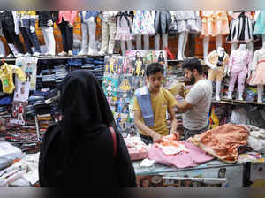 Vendor folds a dress at his clothes shop in Sanaa