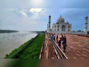 Agra: Visitors look at the swollen Yamuna river flowing alongside the Taj Mahal,...