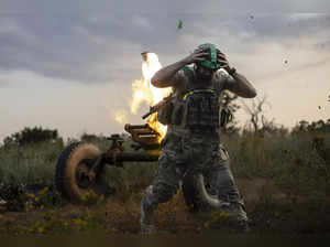 A Ukrainian serviceman of the 3rd Assault Brigade fires a 122mm mortar towards R...