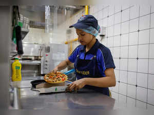 A staff member packs a pizza at a Domino's restaurant in Noida