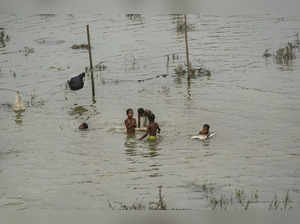 New Delhi: Children play in a flooded area at Mayur Vihar as the swollen Yamuna ...