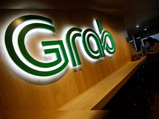 FILE PHOTO: People sit next to a Grab signage in their office in Singapore