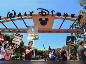 Members of the Writers Guild of America and the Screen Actors Guild walk the picket line outside Disney Studios in Burbank, California, on July 19, 2023. Tens of thousands of Hollywood actors went on strike at midnight July 13, 2023, effectively bringing the giant movie and television business to a halt as they join writers in the first industry-wide walkout for 63 years. (Photo by VALERIE MACON / AFP)
