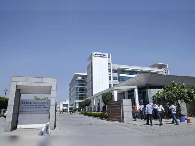 People walk in front of the HCL Technologies Ltd office at Noida