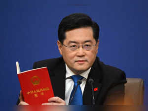 (FILES) China's Foreign Minister Qin Gang holds a copy of China's constitution during a press conference at the Media Center of the National People's Congress (NPC) in Beijing on March 7, 2023. China's foreign minister Qin Gang was removed from office on July 25, 2023, state media reported, after not being seen in the public eye for a month.  (Photo by NOEL CELIS / AFP)