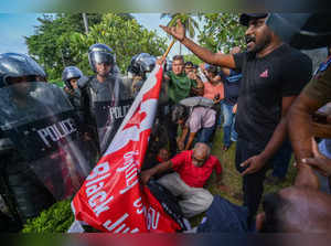 Sri Lankan rights activists scuffle with police during a protest outside the main cemetery in Colombo on July 23, 2023. Sri Lanka tightened security on July 23 as activists lit lamps in Colombo to honour hundreds killed in the 1983 anti-Tamil riots that fuelled a civil war which claimed some 100,000 lives. (Photo by Ishara S. KODIKARA / AFP)