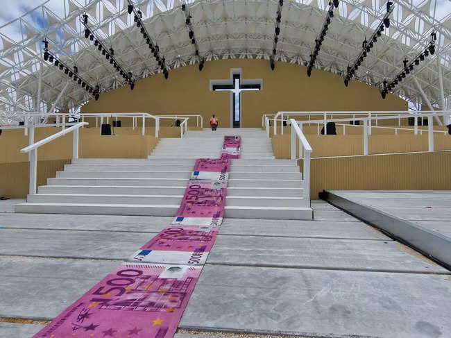 Portuguese artist rolls out banknote carpet to slam pope's visit costs
