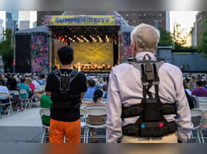 Concertgoers wear haptic suits created for the deaf by Music: Not Impossible, during an outdoor concert at Lincoln Center on July 22, 2023, in New York City.   The violins reverberate in the ribcage, while cello and bass are felt a little further down, with horns in the shoulders, and more often than not, soloists in the wrists. That's one way audio expert Patrick Hanlon programs wireless haptic suits designed to enable the deaf or hard of hearing to experience orchestral music, as initiatives to improve inclusivity at live music performances break new ground. At the Lincoln Center concert,