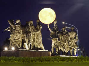 A super moon rises behind a Soviet-era monument for defenders of Leningrad, now ...