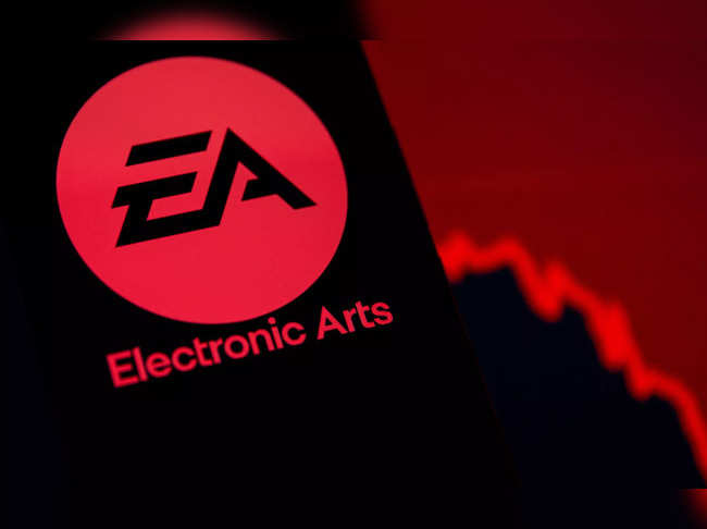A smartphone with the Electronic Arts logo is seen in front of a displayed stock graph in this illustration