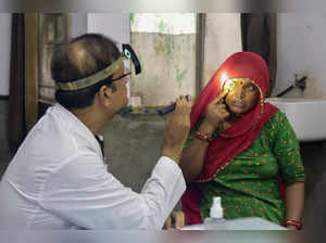 Bikaner: A doctor checks eyes of a woman at a hospital amid rise in Eye Flu (Con...