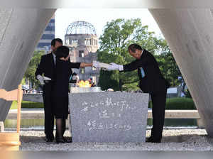 Hiroshima Mayor Kazumi Matsui (R) and representatives of bereaved families enshrine a list of the atomic bomb victims at the cenotaph during a ceremony to mark the 78th anniversary of the world's first atomic bomb attack, at the Peace Memorial Park in Hiroshima on August 6, 2023.  - Japan OUT (Photo by JIJI PRESS / AFP)