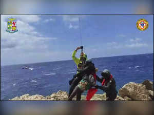 Dozens saved by Italy from migrant shipwrecks; some, clinging to rocks, plucked to safety by copters