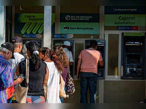 People queue to withdraw money from ATMs at a bank in Havana on August 3, 2023. The Central Bank of Cuba announced on Wednesday that measures had been taken to limit cash transactions and encourage electronic payments in a country beset by high inflation and a liquidity crisis. (Photo by YAMIL LAGE / AFP)